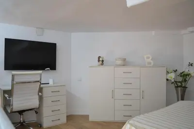 a bedroom with a bed and a desk with a television at Apartamento en Playa Victoria in Cádiz