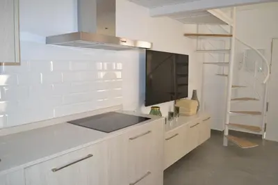 a kitchen with a counter with a tv on the wall at Apartamento en Playa Victoria in Cádiz