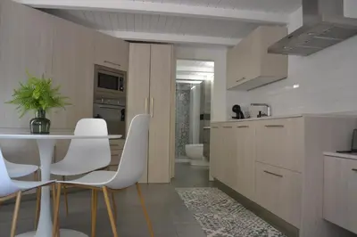 a kitchen with a white table and white chairs at Apartamento en Playa Victoria in Cádiz