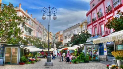 a group of people walking around a street market at Suite del Mercado Little Apartments in Cádiz