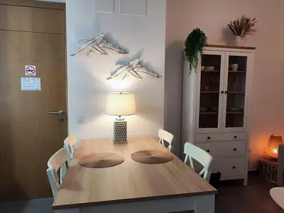 a dining room table with chairs and a lamp at Suite del Mercado Little Apartments in Cádiz