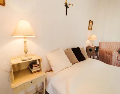 a bedroom with a bed with a lamp and a chair at Andalusian beach haven villa in El Puerto de Santa María