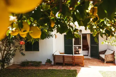 a house with green shuttered windows and a patio at Andalusian beach haven villa in El Puerto de Santa María