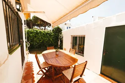 a wooden table and chairs on a patio at Andalusian beach haven villa in El Puerto de Santa María