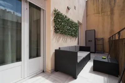 a balcony with a couch and a plant on the wall at Casa Palacio la Mar Salá in El Puerto de Santa María