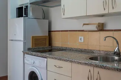 a kitchen with a white refrigerator and a sink at Casa Palacio la Mar Salá in El Puerto de Santa María