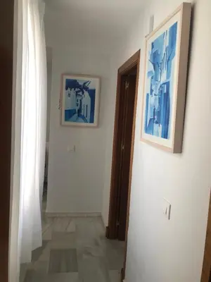 a hallway with two pictures on the wall and a door at Centro de Sanlúcar in Sanlúcar de Barrameda