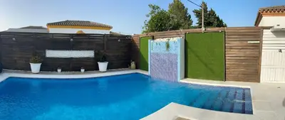 a swimming pool with a privacy fence and a shower at Casa Manolete in Chiclana de la Frontera