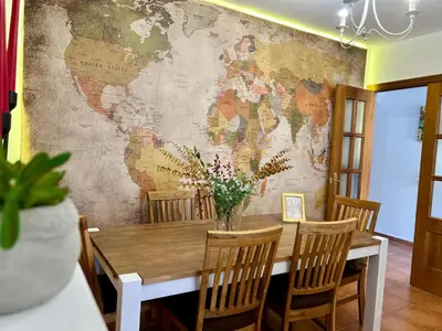a dining room with a table with a map on the wall at Casa Manolete in Chiclana de la Frontera