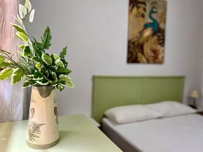 a vase of flowers on a table in a bedroom at Casa Manolete in Chiclana de la Frontera