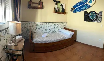 a bedroom with a bed and a table with a lamp at Casa Manolete in Chiclana de la Frontera