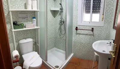 a bathroom with a shower and a toilet and a sink at Casa Manolete in Chiclana de la Frontera