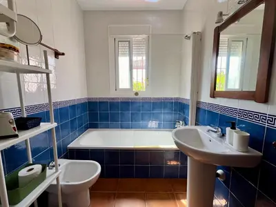 a blue and white bathroom with a tub and a sink at Casa Manolete in Chiclana de la Frontera