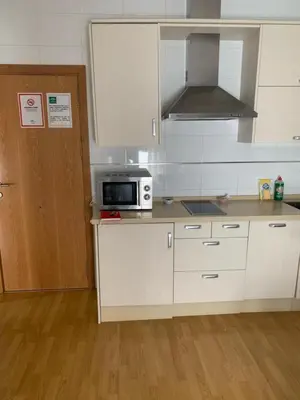 a kitchen with white cabinets and a microwave at ARCO PLAZA DE ESPAÑA CADIZ in Cádiz