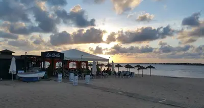 a bar on the beach with chairs and umbrellas at Apartamento céntrico JARDINES DE LA INFANTA, con garaje privado in Sanlúcar de Barrameda