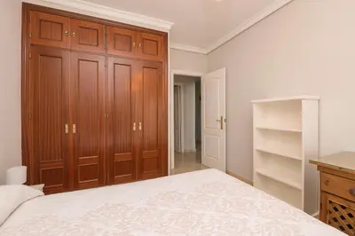 a bedroom with a bed and wooden cabinets at Playamar in Cádiz