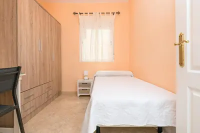 a small bedroom with a bed and a window at Playamar in Cádiz