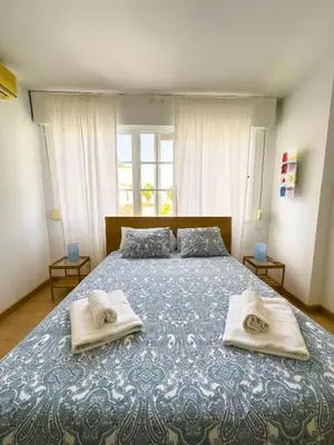 a bedroom with a bed with towels on it at Magnífico Dúplex Nueva Andalucía, 3 habitaciones y vistas a la playa in Sanlúcar de Barrameda