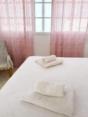 a white bed with two towels on top of it at Magnífico Dúplex Nueva Andalucía, 3 habitaciones y vistas a la playa in Sanlúcar de Barrameda