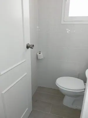 a white bathroom with a toilet and a window at Brisas de Puerto Real in Puerto Real