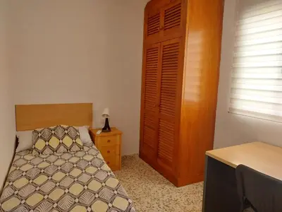 a bedroom with a bed and a wooden cabinet at Brisas de Puerto Real in Puerto Real