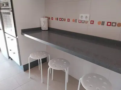 a kitchen with two stools in front of a counter at Brisas de Puerto Real in Puerto Real