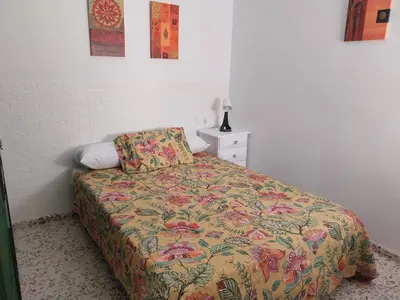 a bedroom with a bed with a floral comforter at Brisas de Puerto Real in Puerto Real
