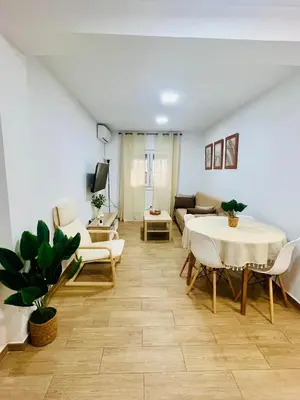 a living room with a table and chairs and a couch at Adana Beach House in Cádiz