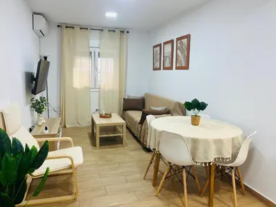 a living room with a table and a couch at Adana Beach House in Cádiz