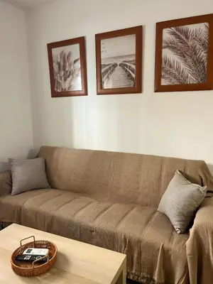 a living room with a brown couch and a table at Adana Beach House in Cádiz