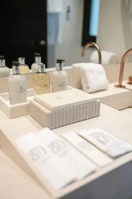 a bathroom counter with two bottles of soap and towels at Hotel Boutique Sidonia in Jerez de la Frontera