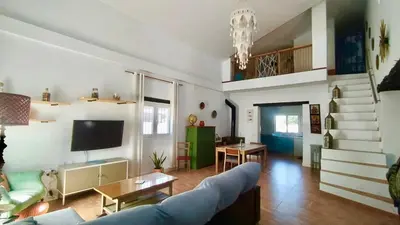 a living room with a blue couch and a tv at villa rana verde in Chiclana de la Frontera