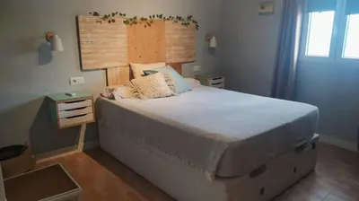 a bedroom with a large bed with a wooden headboard at villa rana verde in Chiclana de la Frontera