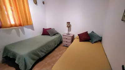 a bedroom with two beds and a dresser in it at villa rana verde in Chiclana de la Frontera