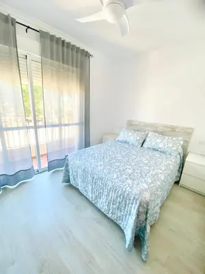 a bedroom with a bed and a large window at Unifamiliar Chiclana, La Barrosa in Chiclana de la Frontera