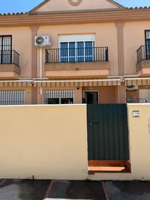 a house with a green door and a fence at Unifamiliar Chiclana, La Barrosa in Chiclana de la Frontera