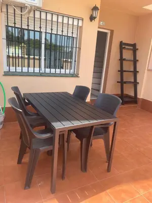 a wooden dining table and chairs in a room at Unifamiliar Chiclana, La Barrosa in Chiclana de la Frontera