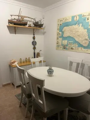 a dining room with a white table and chairs at Casa en la playa 750 m La Barrosa in Cádiz