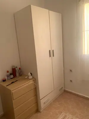 a bedroom with a white cabinet and a wooden dresser at Casa en la playa 750 m La Barrosa in Cádiz