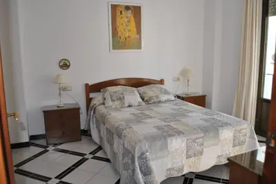 a bedroom with a bed with two night stands and two lamps at Apartamento LUNA in Arcos de la Frontera