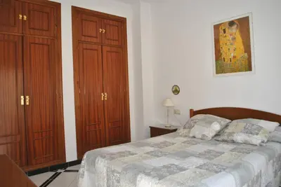 a bedroom with a bed and two wooden cabinets at Apartamento LUNA in Arcos de la Frontera