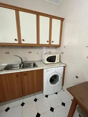 a kitchen with a washing machine and a microwave at Apartamento SOL in Arcos de la Frontera