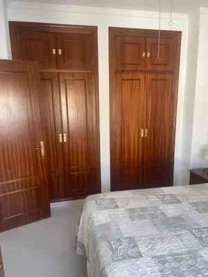 a bedroom with wooden cabinets and a bed at Apartamento SOL in Arcos de la Frontera