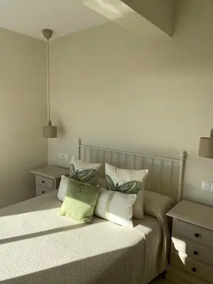 a bedroom with a bed with pillows on it at La ilusión de Pepa in El Puerto de Santa María