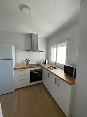 a kitchen with white cabinets and a white refrigerator at La ilusión de Pepa in El Puerto de Santa María
