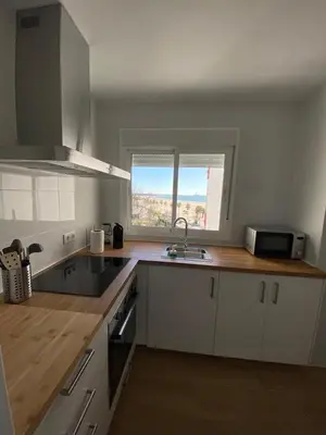 a kitchen with white cabinets and a sink and a window at La ilusión de Pepa in El Puerto de Santa María