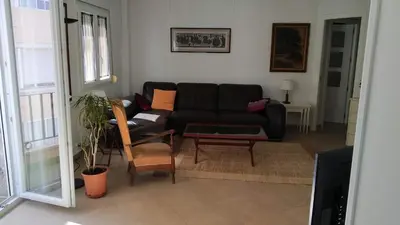a living room with a black couch and a table at Piso en la Caleta in Cádiz