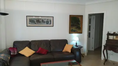 a living room with a brown couch and a table at Piso en la Caleta in Cádiz