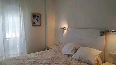 a bedroom with a bed with a white headboard at Piso en la Caleta in Cádiz