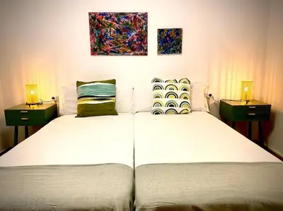 two beds in a bedroom with two lamps on them at MyChoice Casa Milagros in Rota